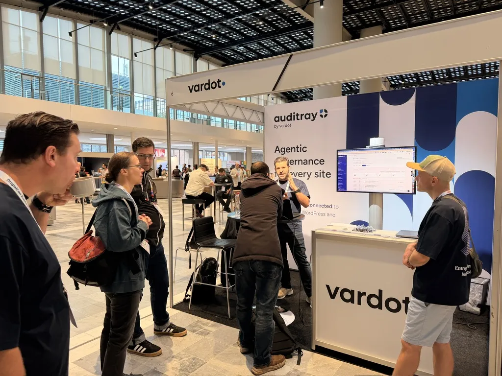 A small crowd gathered at the Auditray booth while a Vardot team member demonstrates the product.