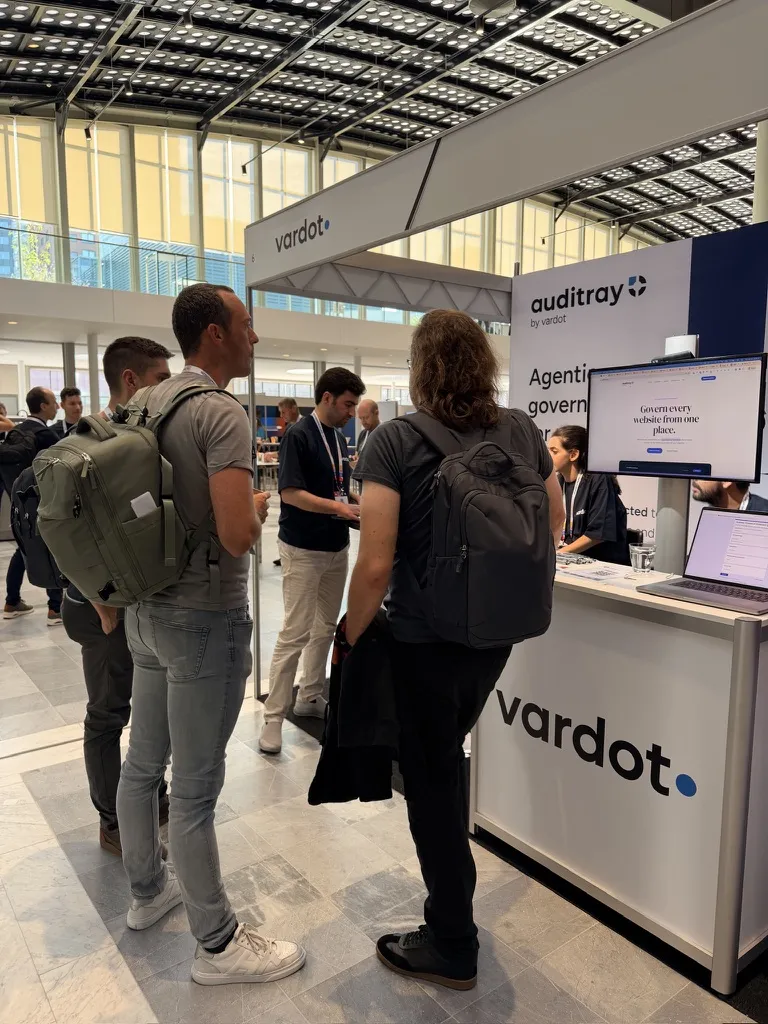 Visitors at the Auditray booth looking at the product on a screen.